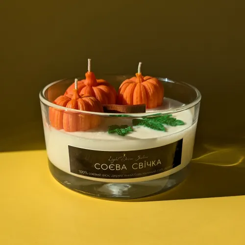 Свічка в скляному підсвічнику з декором гарбузів