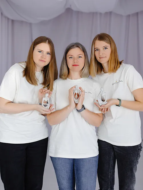 Три жінки з статуетками ручної роботи в руках